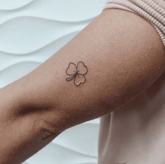 a small four leaf clover tattoo on the arm