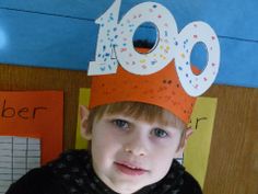 a young boy wearing a paper hat made to look like an orange and white number