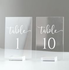 two clear acrylic table numbers sitting on top of each other