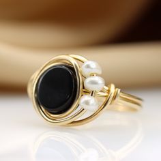 The perfect combination between Black and White This unique wire ring is set with a genuine Black onyx and three Fresh water pearls ☆ WHY THIS PIECE OF J E W E L R Y IS AWESOME! ☆ * Hand finished and made from high quality raw materials * Long lasting beauty & Timeless design ♡ WRAPPING ♡ * All 23 Summers jewels arrive in a cute pouch or gift box so they are gift ready. DELIVERY ✉ * Most items are ready made but some are made to order, Times for each items are shown on * Well packaged for do Elegant Wire Wrapped Round Rings, Black Hand Wrapped Round Jewelry, Black And White Ring, Black And White Rings, Ring Pearl, Ring Wire, Wire Wrapped Ring, Wire Ring, Knot Ring