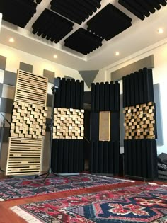 an array of black and gold acoustic panels in a room with rugs on the floor