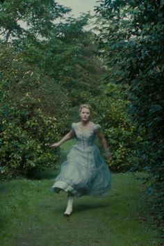 a woman in a dress is running through the grass