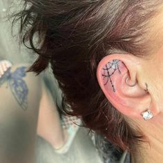 a woman with tattoos on her left ear