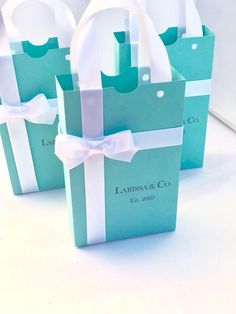 three bags with white bows on them sitting next to each other