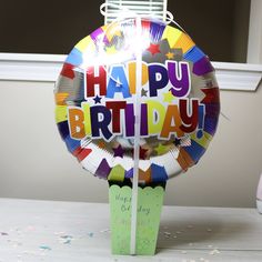 a birthday balloon sitting on top of a table