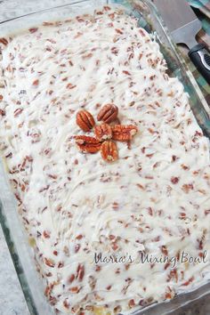 a glass baking dish with pecans on top