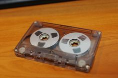 two audio tape recorders sitting on top of a wooden table