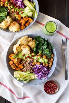 two bowls filled with different types of food on top of a white cloth next to a fork