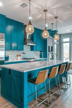 a kitchen with blue cabinets and white counter tops, an island in the middle is surrounded by bar stools