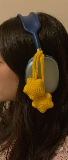 a close up of a person with a hair dryer on their head, wearing a crocheted hat