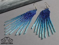 a pair of blue beaded earrings sitting on top of a table