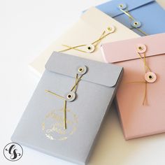 three different colored envelopes with string attached to them