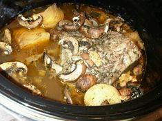 the meat is being cooked in the crock pot with mushrooms and broccoli