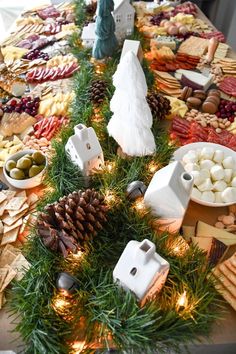 an assortment of food on a table with pine cones and other holiday foods around it