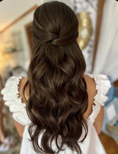 the back of a woman's head with long brown hair and curls in it