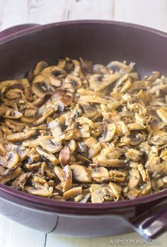 a pan filled with mushrooms on top of a wooden table