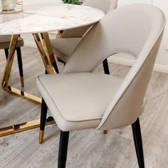 a marble dining table and chairs with gold trim around the legs in a white room