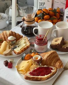 an assortment of cheeses, jam and bread on plates