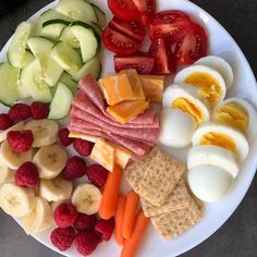 a white plate topped with fruits and veggies next to hard boiled egg shells