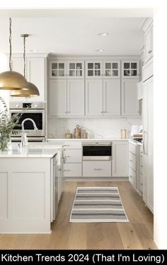 a kitchen with white cabinets and an area rug