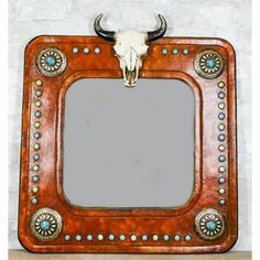 a cow skull mounted to the side of a wooden frame with rivets on it