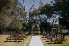 an outdoor ceremony set up with wooden chairs