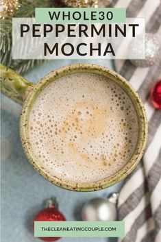 a cup of peppermint mocha on top of a table next to christmas decorations