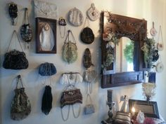 there are many purses hanging on the wall next to each other, and one is holding a candle