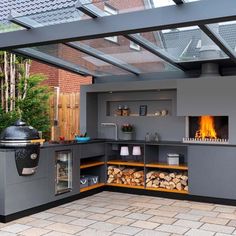 an outdoor kitchen with a grill and fire place