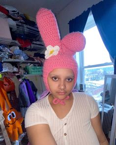 a woman wearing a pink knitted bunny ears hat