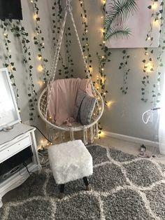 a room with a chair, rug and lights on the wall behind it is decorated with greenery