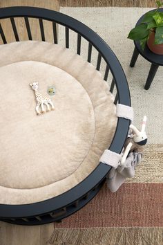 a baby crib with a toy giraffe on the floor next to it