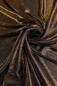 Bronze Metallic Foil Lame fabric is a luxurious fabric that is shiny and colorful. Lame (pronounced la-may) is usually a knit fabric with a metallic coating on the surface. This Bronze Metallic Foil Lame fabric is gorgeous and lightweight, has a beautiful metallic look and a crispy textured feel. Perfect for costume, performance wear, upholstrey, draperies, cushion, slip covers, skirts, jackets and dresses. Purchase fabric by the Yard at NY Designer Fabrics. The fabric measures 58/60 inches in width. Glamorous Metallic Shiny Sequin Fabric, Glamorous Metallic Sequin Fabric, Metallic Sequin Fabric With Shimmer For Evening, Shiny Metallic Sequin Fabric For Evening, Metallic Shiny Sequin Fabric For Evening, Metallic Shimmer Sequin Fabric For Evening, Metallic Stretch Sequin Fabric With Glitter, Stretch Metallic Sequin Fabric With Glitter, Stretch Shiny Sequin Fabric