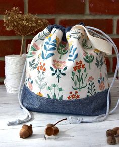 a drawstring bag sitting on top of a table next to nuts and flowers