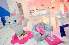 a room filled with lots of furniture and decor in pink, white and blue colors