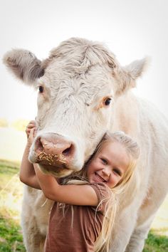 a girl hugging a cow in a field