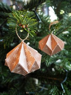 two origami ornaments hanging from a christmas tree