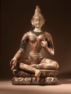 an old statue sitting on top of a wooden table