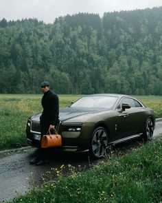 a man standing next to a car with luggage on the road in front of it