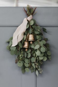 a wreath with bells and greenery hangs on the front door