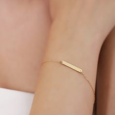 The handcrafted gold stacking bracelet features a slim bar pendant connected to a delicate cable chain, making it a versatile accessory suitable for both casual and formal occasions. It can be worn elegantly on its own or paired with any of our other beautiful bracelets. You'll receive: Handcrafted 18K Vermeil gold jewelry Jewelry sourced entirely from the USA Specifications: Material: 18K Vermeil Gold Cut: Excellent Dimensions: Height: 4 mm / 0.15 in Width: 12 mm / 0.47 in Chain Style: Cable Ch Bar Bracelet Personalized, Minimal Gold Jewelry, Gold Bar Bracelet, Gold Schmuck, Bar Bracelet, Gold Armband, Gold Bracelet For Women, Bar Bracelets, Bar Pendant