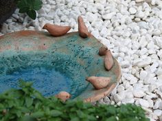 a bird bath surrounded by rocks and plants