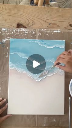 a person is painting on a piece of paper