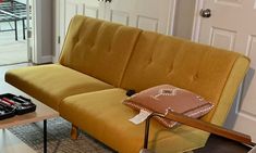 a living room with a yellow couch and coffee table