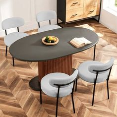 a dining table with four chairs and a bowl of fruit on it in a room