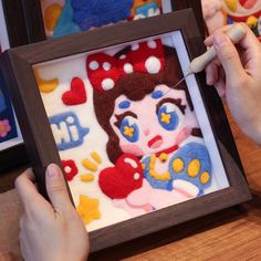 someone is working on an art project with felt and yarn in front of the frame