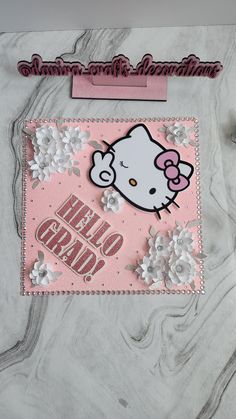 a hello kitty card with some flowers on the front and side, sitting on a marble surface