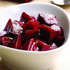 a white bowl filled with beets on top of a table