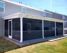 the back porch of a two story house with white railings and windows on each side