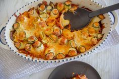 a casserole dish with zucchini and cheese in it on a table